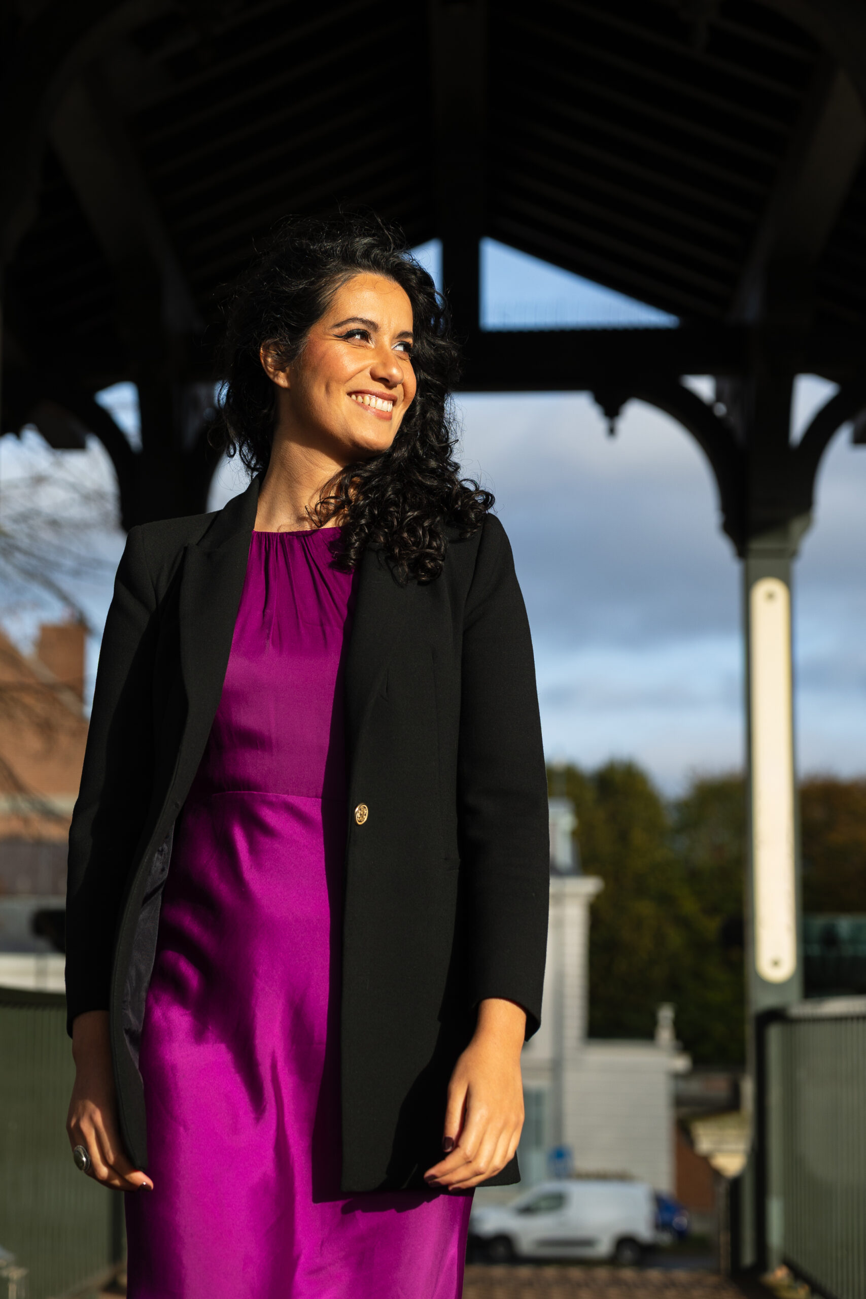 Nora Raya, souriante, sous un kiosque en bois